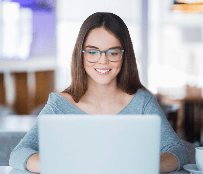 Mujer sonriendo frente a un computador